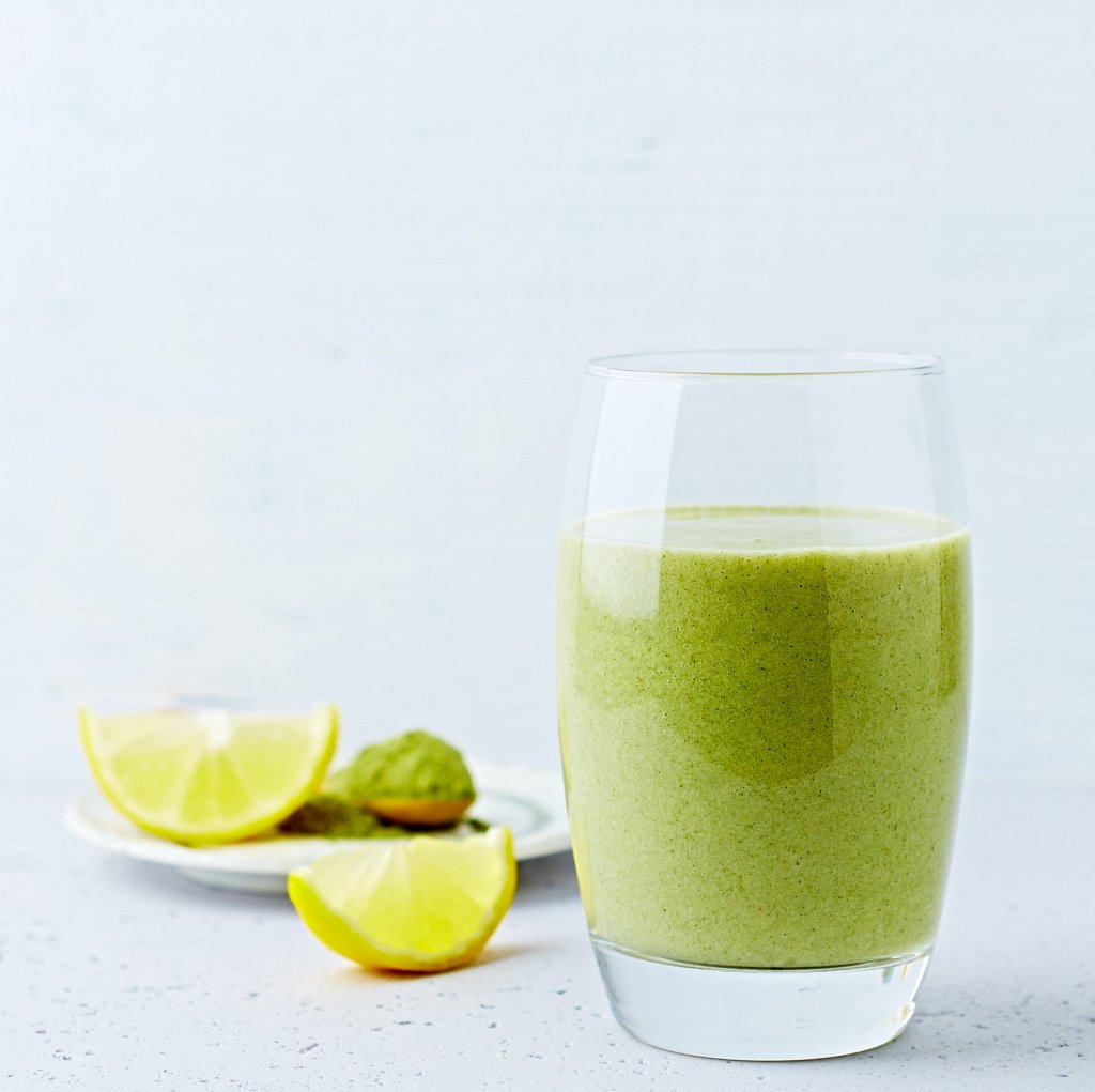 Avocado-banana smoothie made with almond milk and young barley grass. Copy space. Healthy diet. Natural food